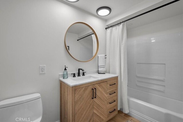 full bathroom with vanity, hardwood / wood-style floors, shower / tub combo with curtain, and toilet