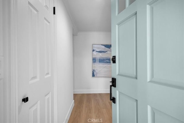 hallway with crown molding and light hardwood / wood-style floors