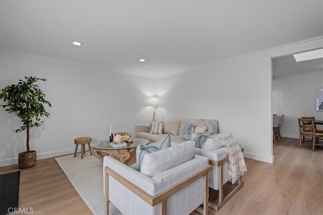 living room with crown molding, a skylight, and light wood-type flooring