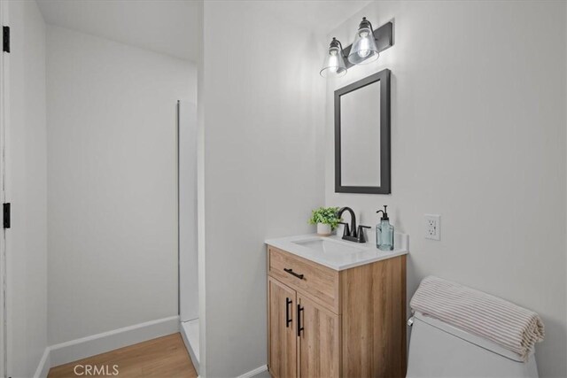 bathroom with vanity, wood-type flooring, and toilet