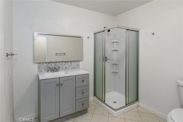 bathroom with vanity, a shower with shower door, tile patterned floors, and toilet