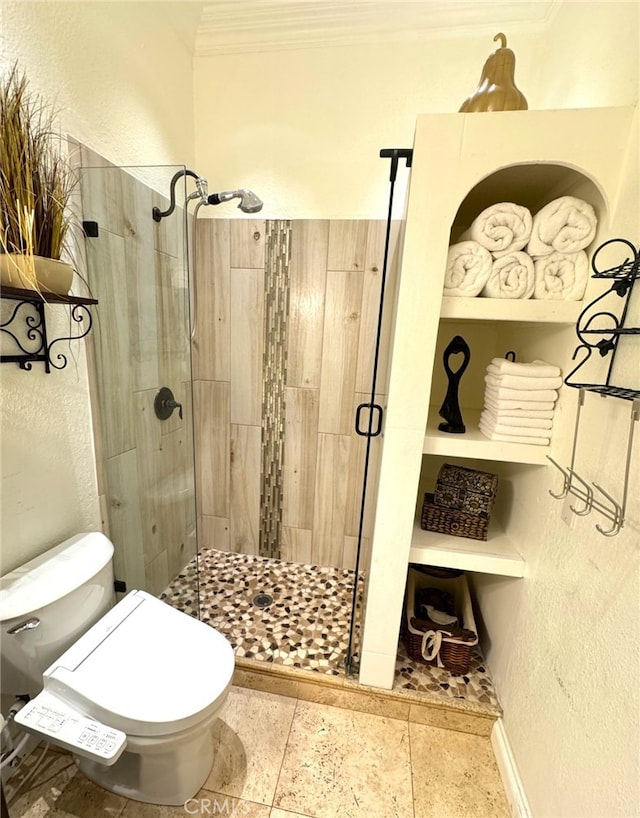 bathroom with ornamental molding, toilet, and a shower with door