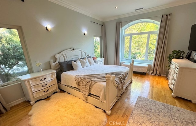 bedroom featuring crown molding and light hardwood / wood-style floors