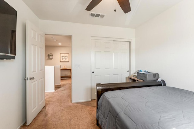 bedroom featuring light carpet, ceiling fan, and a closet