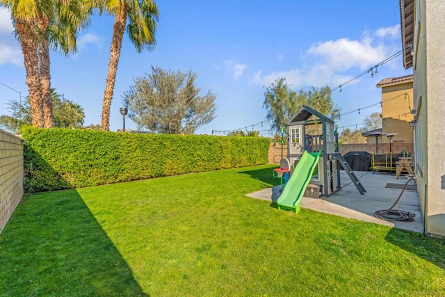 view of yard featuring a playground and a patio area