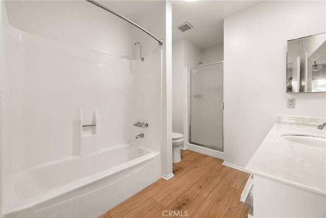 full bathroom with hardwood / wood-style flooring, vanity, tub / shower combination, and toilet