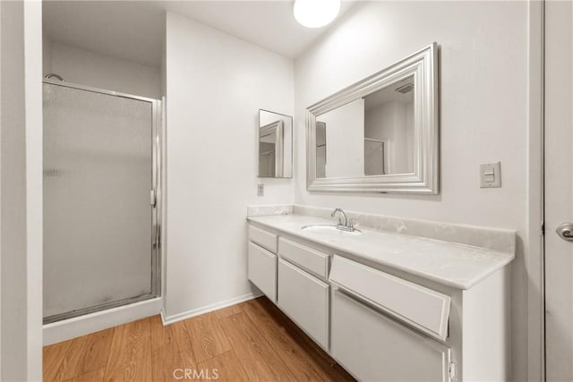 bathroom with vanity, wood-type flooring, and a shower with shower door