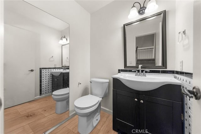 bathroom featuring hardwood / wood-style flooring, vanity, and toilet