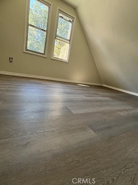 bonus room featuring dark wood-type flooring and lofted ceiling