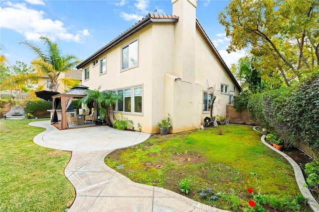 view of home's exterior featuring a gazebo, a patio area, and a lawn