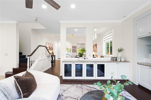 living room featuring ceiling fan, ornamental molding, and dark hardwood / wood-style floors