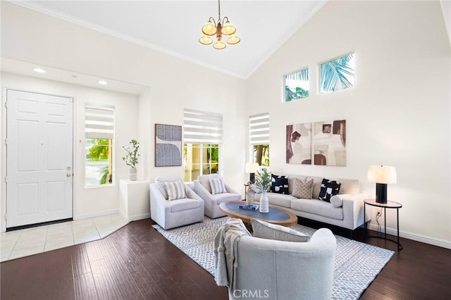 living room with wood-type flooring, crown molding, a chandelier, and high vaulted ceiling