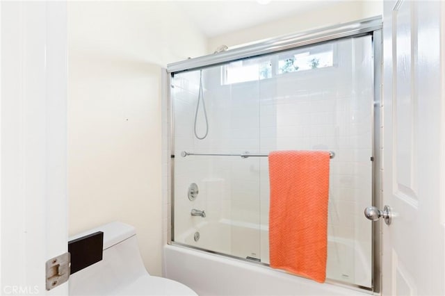 bathroom with shower / bath combination with glass door and toilet