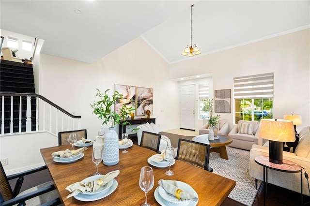 dining area featuring crown molding, lofted ceiling, and a chandelier