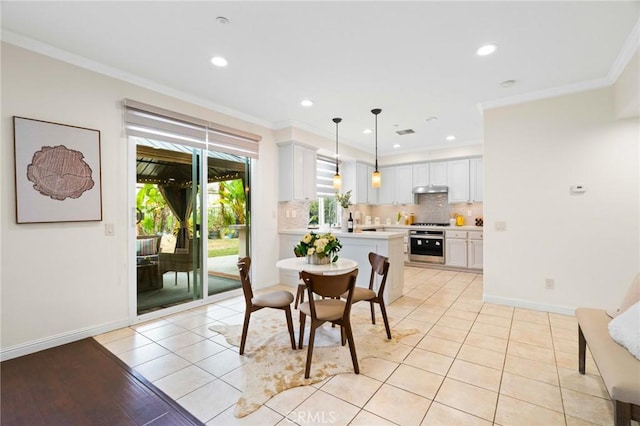 tiled dining space featuring ornamental molding