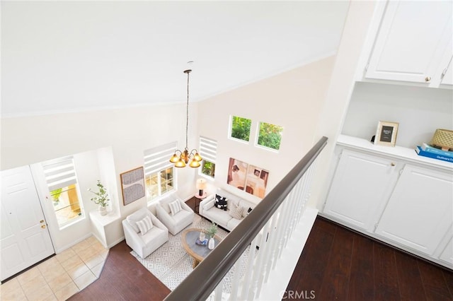 interior space with dark wood-type flooring, high vaulted ceiling, and a notable chandelier