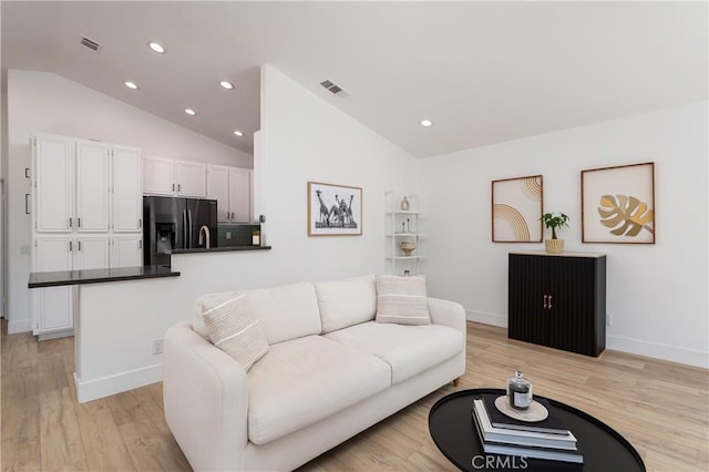 living room with vaulted ceiling and light hardwood / wood-style flooring