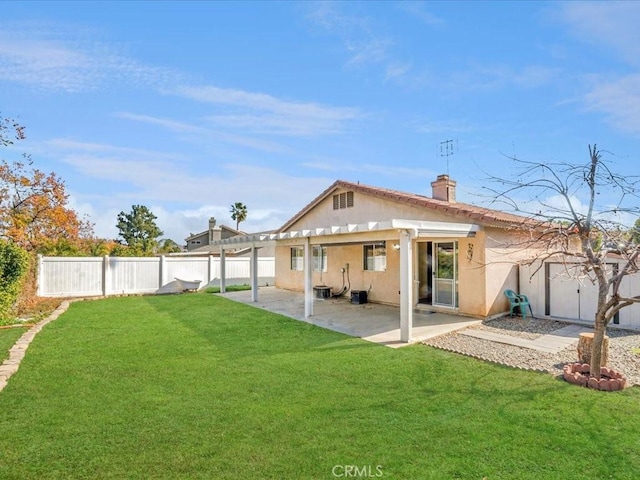 rear view of property with a fenced backyard, a yard, a chimney, and a patio