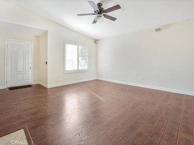 empty room featuring ceiling fan, lofted ceiling, dark wood-type flooring, visible vents, and baseboards