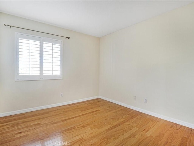 unfurnished room featuring baseboards and light wood-style floors