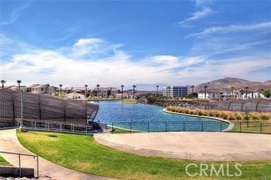 view of pool featuring a water view and fence