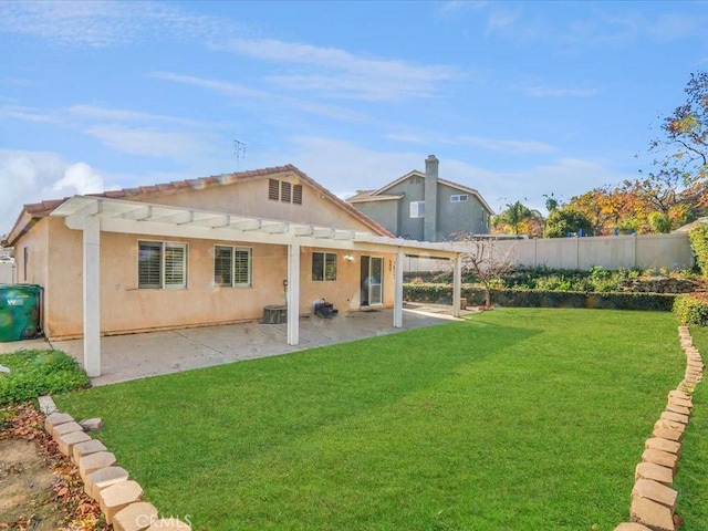 rear view of property with a patio, stucco siding, a lawn, fence, and a pergola