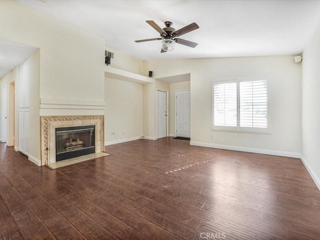 unfurnished living room featuring baseboards, vaulted ceiling, dark wood-style flooring, and a high end fireplace