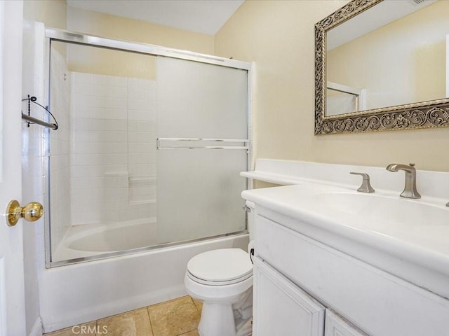 bathroom featuring bath / shower combo with glass door, vanity, tile patterned flooring, and toilet