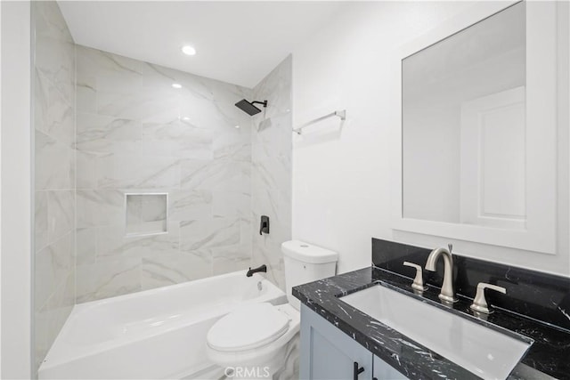 full bathroom featuring tiled shower / bath, vanity, and toilet