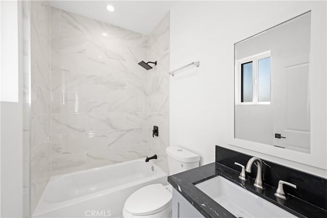 full bathroom featuring tiled shower / bath, vanity, and toilet