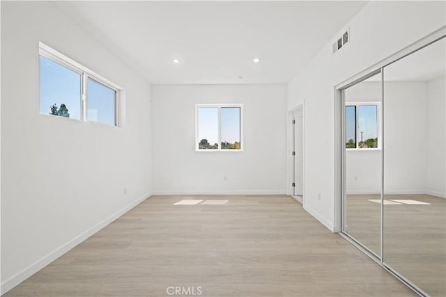 unfurnished room featuring a wealth of natural light and light hardwood / wood-style flooring