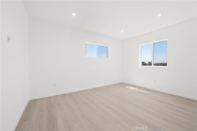 empty room featuring a wealth of natural light and light hardwood / wood-style floors