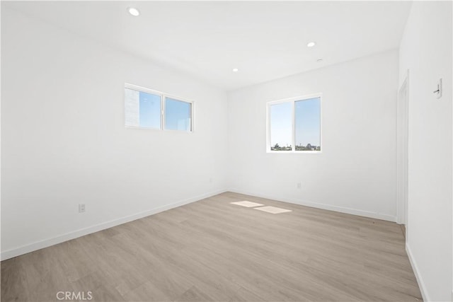 spare room featuring light hardwood / wood-style floors and a healthy amount of sunlight