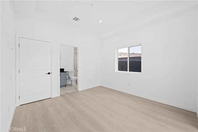 unfurnished bedroom with connected bathroom and light hardwood / wood-style flooring