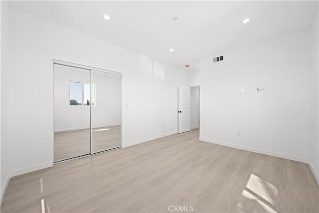 unfurnished bedroom with light hardwood / wood-style floors and a closet