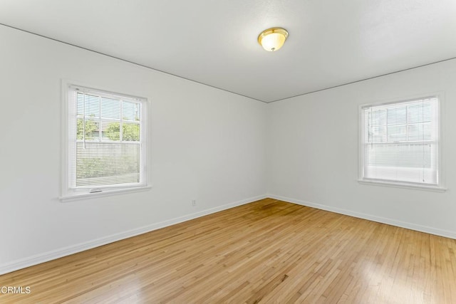 empty room with baseboards and light wood-style floors