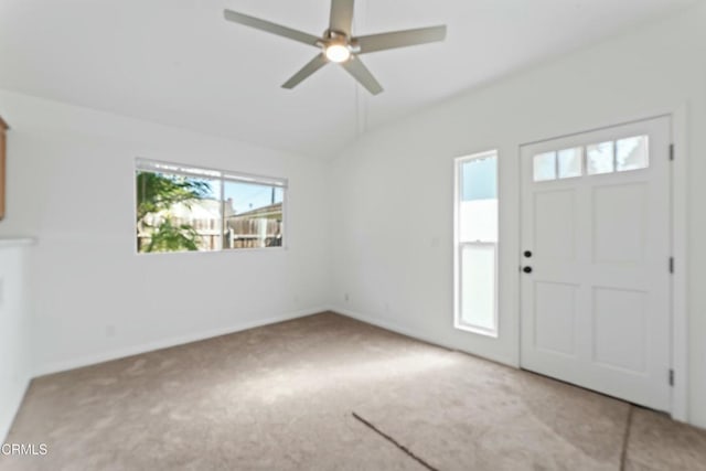 entrance foyer with vaulted ceiling, ceiling fan, and light colored carpet