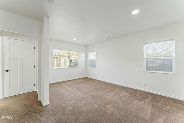 empty room featuring baseboards, recessed lighting, and light colored carpet