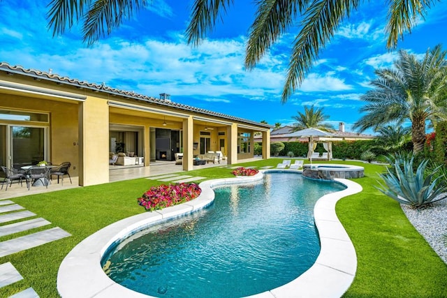 view of swimming pool with an in ground hot tub, a patio, and a lawn