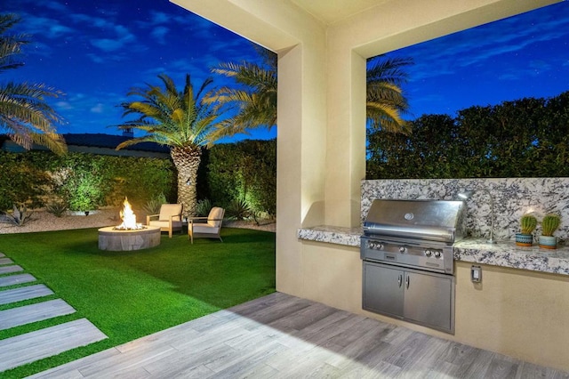 view of patio featuring an outdoor kitchen, grilling area, and a fire pit