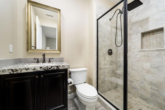 bathroom with vanity, toilet, and a shower with door