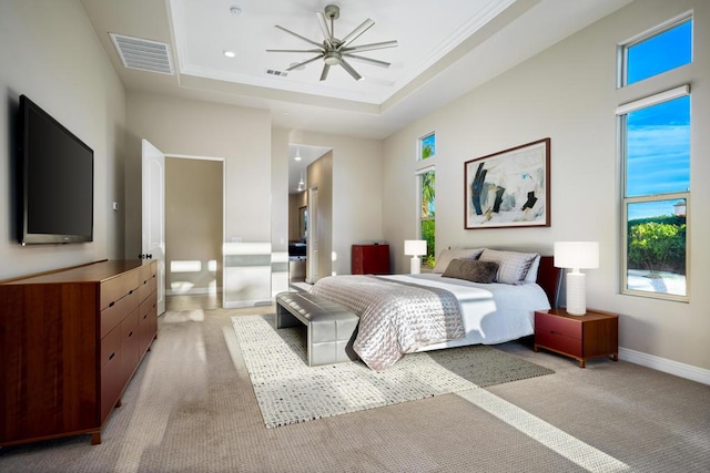 bedroom with a tray ceiling and light carpet