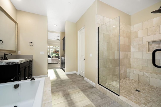 bathroom with vanity, hardwood / wood-style flooring, and plus walk in shower