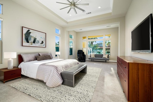 carpeted bedroom featuring crown molding, a tray ceiling, ceiling fan, and a high ceiling