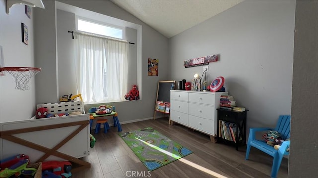 recreation room with dark wood-type flooring, a healthy amount of sunlight, and vaulted ceiling