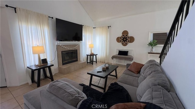 tiled living room featuring lofted ceiling and a fireplace