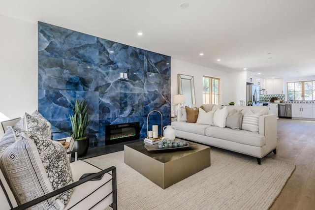 living room with a tile fireplace and hardwood / wood-style floors