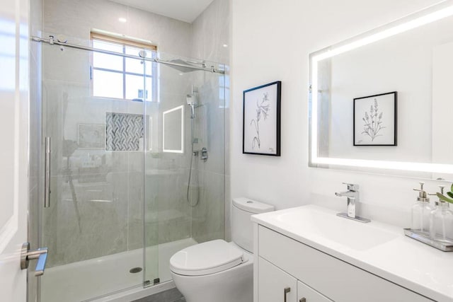 bathroom featuring toilet, vanity, and walk in shower