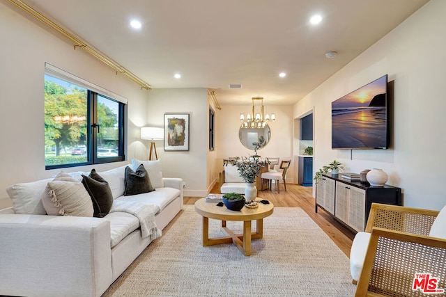 living room featuring an inviting chandelier and light hardwood / wood-style floors