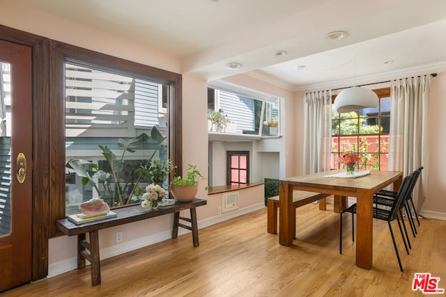 dining area featuring crown molding and light hardwood / wood-style floors